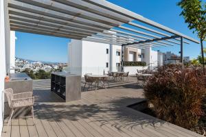 un patio con tavoli e sedie su una terrazza di Luxury 3BR Garden Apartment Estepona a Estepona