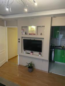 Una sala de estar con un televisor de pantalla plana grande en una pared. en Panorama Bulevar, en Niš