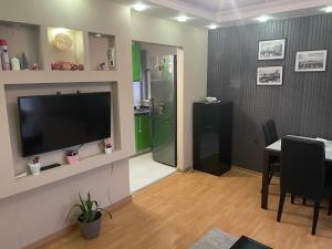 Una sala de estar con televisión y un comedor. en Panorama Bulevar, en Niš