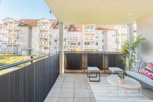 a balcony with a couch and tables and buildings at Goldstadt Fancy Apartment in Pforzheim