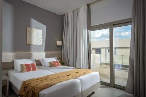 um quarto de hotel com duas camas e uma grande janela em Saint George Gournes Bay em Goúrnai