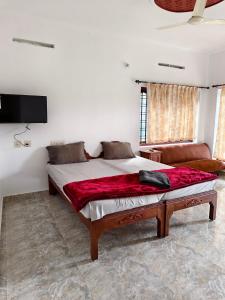 Un dormitorio con una cama grande y un sofá. en Wild Forest Inn Thekkady, en Thekkady