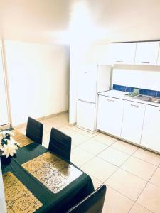 a kitchen with a table and chairs and a kitchen with white cabinets at F2 Escale CDG calme à 20 mins de paris , Stade 2 France, Aéro CDG, Parc des expositions, Disneyland Paris,Futuroscope, Tour Eiffel in Arnouville-lès-Gonesse