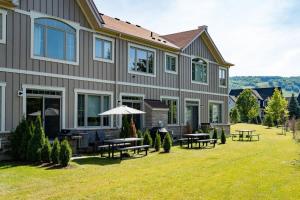 ein großes Haus mit Bänken und Tischen im Hof in der Unterkunft Luxury Townhome - Private Patio Shuttle Trails in Collingwood