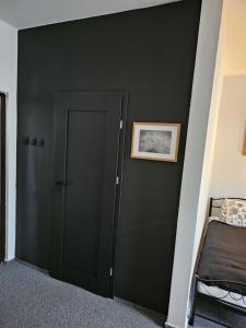 een slaapkamer met een donkergroene muur en een deur bij Pokój 105 Comfort 