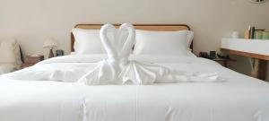 a white bed with white sheets and white shoes on it at Aya Beach Resort Koh Lipe in Ko Lipe +40 photos