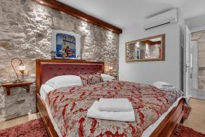マカルスカにあるVilla Old Town Centre Makarska - Makarska Exklusivの石壁のベッドルーム1室(大型ベッド1台付) +17枚の写真