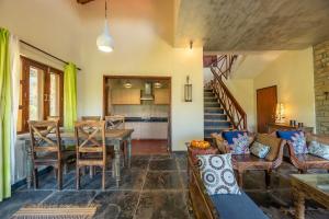 een woonkamer met een tafel en een eetkamer bij Wild Thyme - Levitate at Ramgarh by Roamhome in Rāmgarh