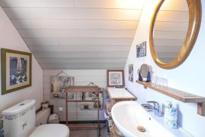 a bathroom with a sink and a toilet and a mirror at L'écrin de bois -sauna - spa in Mur-de-Bretagne