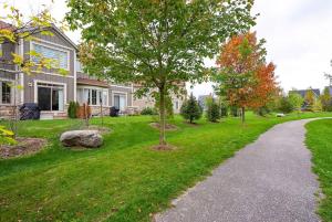 una casa con un albero nel cortile di Blue Mountain Townhome - Patio Shuttle Trails a Collingwood