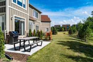 un cortile con tavolo da picnic e griglia di Blue Mountain Townhome - Patio Shuttle Trails a Collingwood