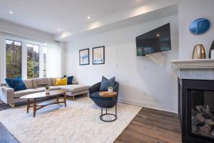 un soggiorno con camino e TV di Blue Mountain Townhome - Patio Shuttle Trails a Collingwood Altre 42 foto