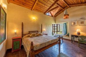 een slaapkamer met een groot bed in een kamer bij Wild Thyme - Levitate at Ramgarh by Roamhome in Rāmgarh