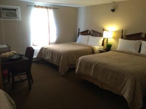 a hotel room with two beds and a window at The Falls Family Lodge in Niagara Falls