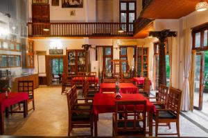 特里凡得琅By The Bay Kovalam的摆着红色桌椅的餐厅