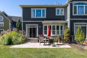 ein schwarzes Haus mit Terrasse und Rasen in der Unterkunft Luxury Mountain Townhome - Shuttle Patio & Trails in Collingwood