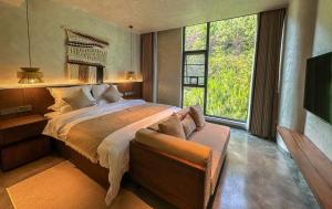 een slaapkamer met een groot bed en een groot raam bij LongSen Valley Inn in Zhukeng