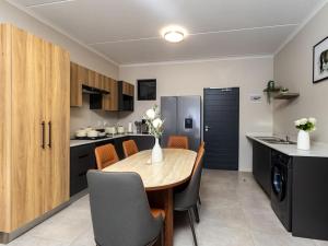 Woodland Haven في ميدراند: مطبخ وغرفة طعام مع طاولة وكراسي خشبية +صورتان