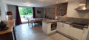 una cucina con mobili bianchi e un tavolo con sedie di Chez adele a Bouvellemont