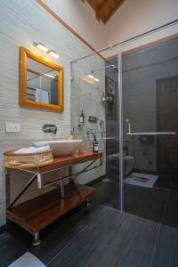 a bathroom with a sink and a glass shower at ELIVAAS Tapovan Estate 2-BHK With Kids Attic, Garden, Gazebo and Scenic Views in Bhowāli +131 photos