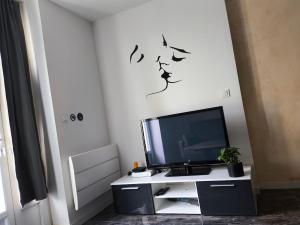 einen Flachbild-TV auf einem weißen Entertainment-Center in der Unterkunft Apocalypse Love Room in Vianne