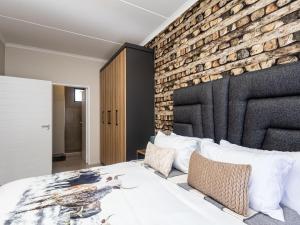 Woodland Haven في ميدراند: غرفة نوم بحائط من الطوب وسرير