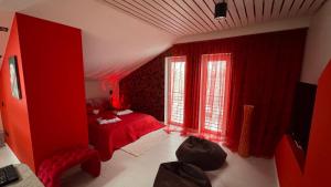 a red bedroom with a red bed and windows at Rožu romantika in Cēsis
