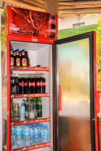 an open refrigerator filled with lots of drinks at Songota Falls Lodge in Arusha
