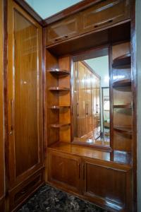 a dressing room with wooden shelves and a mirror at ELIVAAS Tapovan Estate 2-BHK With Kids Attic, Garden, Gazebo and Scenic Views in Bhowāli