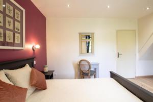 CampsegretChambres d'hôtes du Lac Beausoleil的一间卧室，里面有一张床、一张桌子和一把椅子