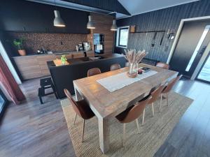a kitchen and dining room with a wooden table and chairs at Winter cabin with Jacuzzi in Vestby