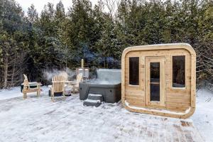 a small wooden cabin with a grill in the snow at The Hideaway - Tiny House in Eugenia
