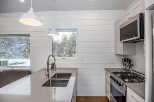 a white kitchen with a sink and a stove at The Hideaway - Tiny House in Eugenia