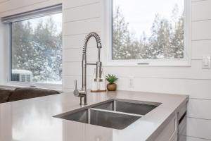 a kitchen with a stainless steel sink and a window at The Hideaway - Tiny House in Eugenia