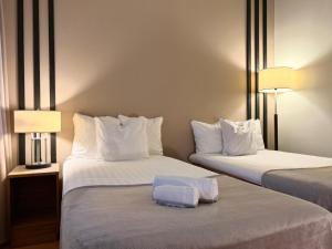 a hotel room with two beds with white pillows at Hotel Jollasranta Helsinki in Helsinki