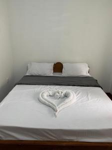 KiriwalagamaFeelATHome STAY - Near sinharajaya的白色床单制成的心床