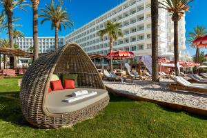 a wicker hammock on the beach at a resort at Hotel Vibra Algarb in Playa d'en Bossa