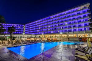 a hotel with a large swimming pool at night at Hotel Vibra Algarb in Playa d'en Bossa