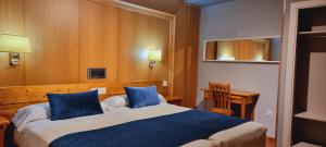 Una habitación de hotel con dos camas con almohadas azules. en Hotel Real De Toledo, en Toledo