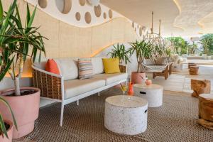 a living room with a couch and potted plants at Hotel Vibra Algarb in Playa d'en Bossa