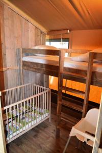 a room with two bunk beds and a crib at Parc Sonnleiten - Safaritent in Gnesau Sonnleiten