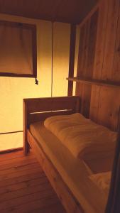 a wooden bed in a room with a window at Parc Sonnleiten - Safaritent in Gnesau Sonnleiten