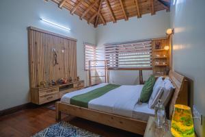 a bedroom with a large bed and a wooden wall at ELIVAAS Tapovan Estate 2-BHK With Kids Attic, Garden, Gazebo and Scenic Views in Bhowāli