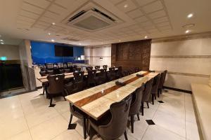 uma sala de conferências com longas mesas e cadeiras de madeira em 3S HOTEL 동탄점 - Boutique em Hwaseong