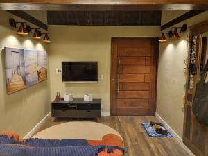 a bedroom with a bed and a tv and a door at CASA em CAMBURI in São Sebastião