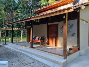 a house with a porch with a couch on it at CASA em CAMBURI in São Sebastião