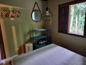 a bedroom with a bed and a mirror and a window at CASA em CAMBURI in São Sebastião +16 photos