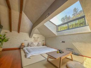 een slaapkamer met een bed en een groot raam bij LongSen Valley Inn in Zhukeng