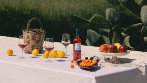 a table with glasses of wine and a bowl of fruit at Tenuta Doxi in Gallipoli