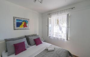 ein Schlafzimmer mit einem Bett mit lila Kissen und einem Fenster in der Unterkunft Villa Toma by Villas Guide in Gornji Dingač + 21 Fotos